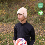 Kille med Sandy Beige SafeHat med boll i handen. Uppe till höger finns två ikoner.