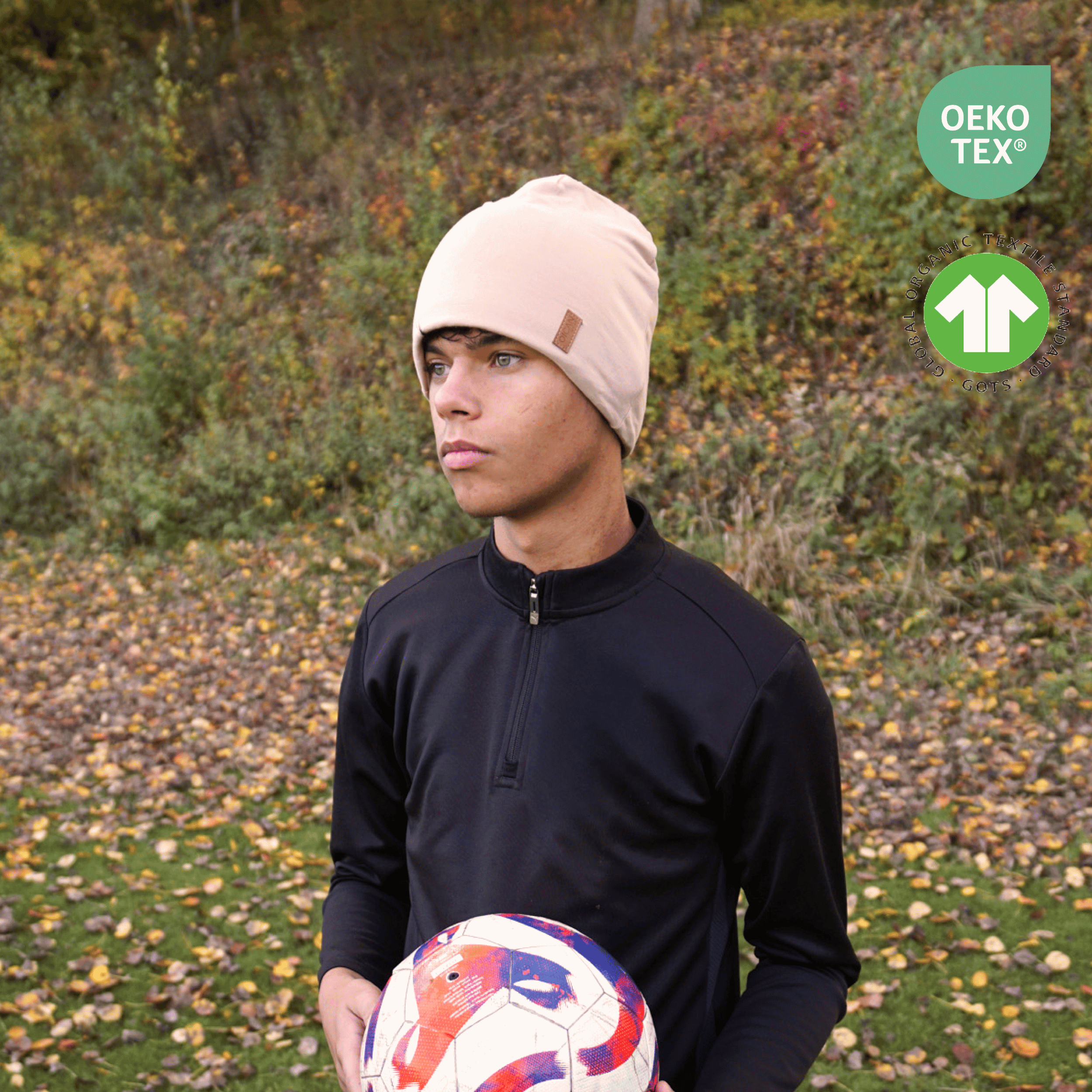 Kille med Sandy Beige SafeHat med boll i handen. Uppe till höger finns två ikoner.