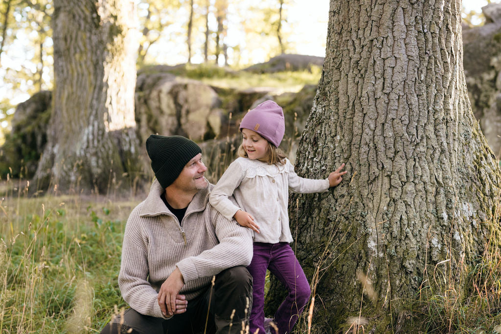 Bild på en man och flicka som bär SafeHats i skogen