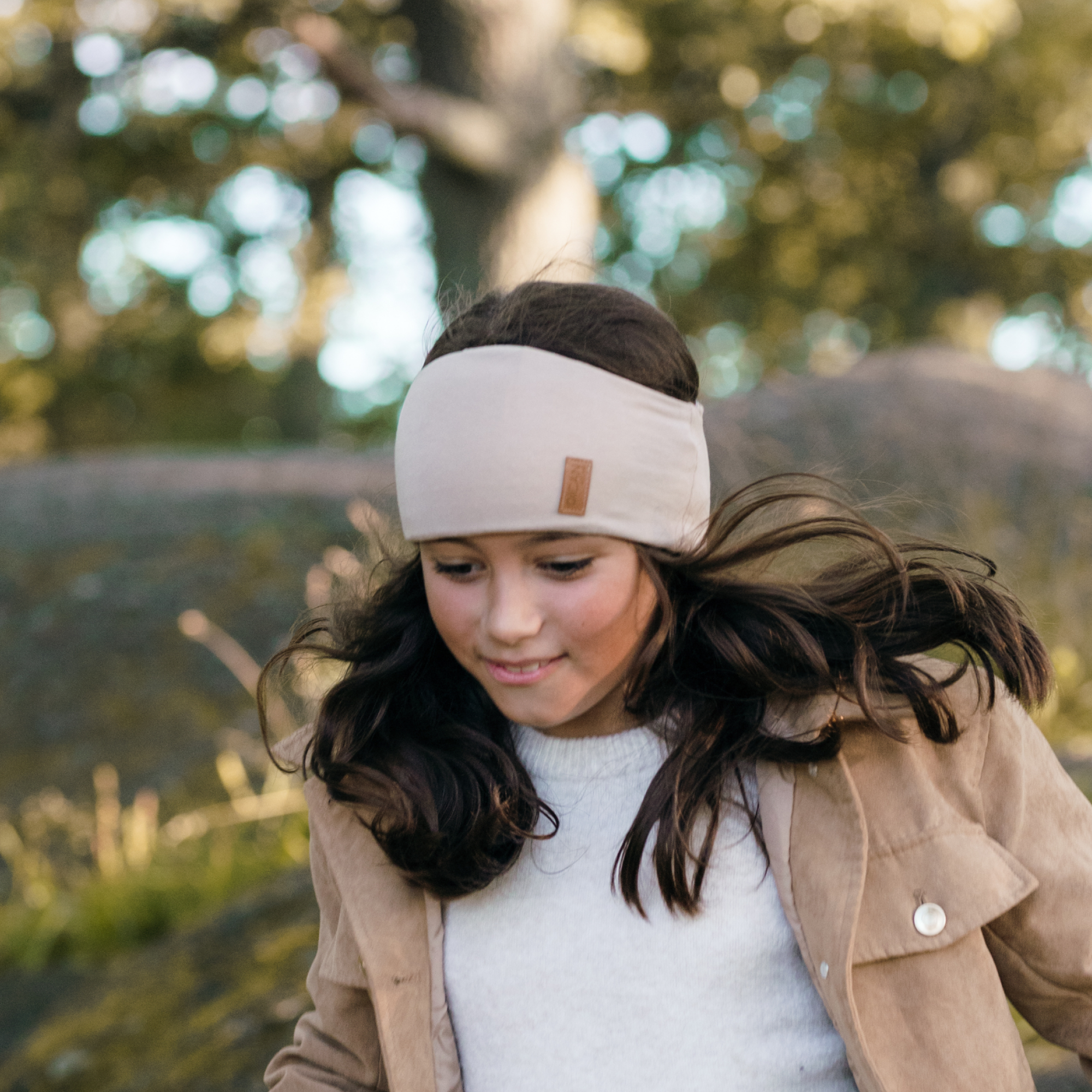 Flicka med beige pannband från OICAN i rörelse
