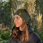 Tjej med grönt pannband från OICAN i skogen.