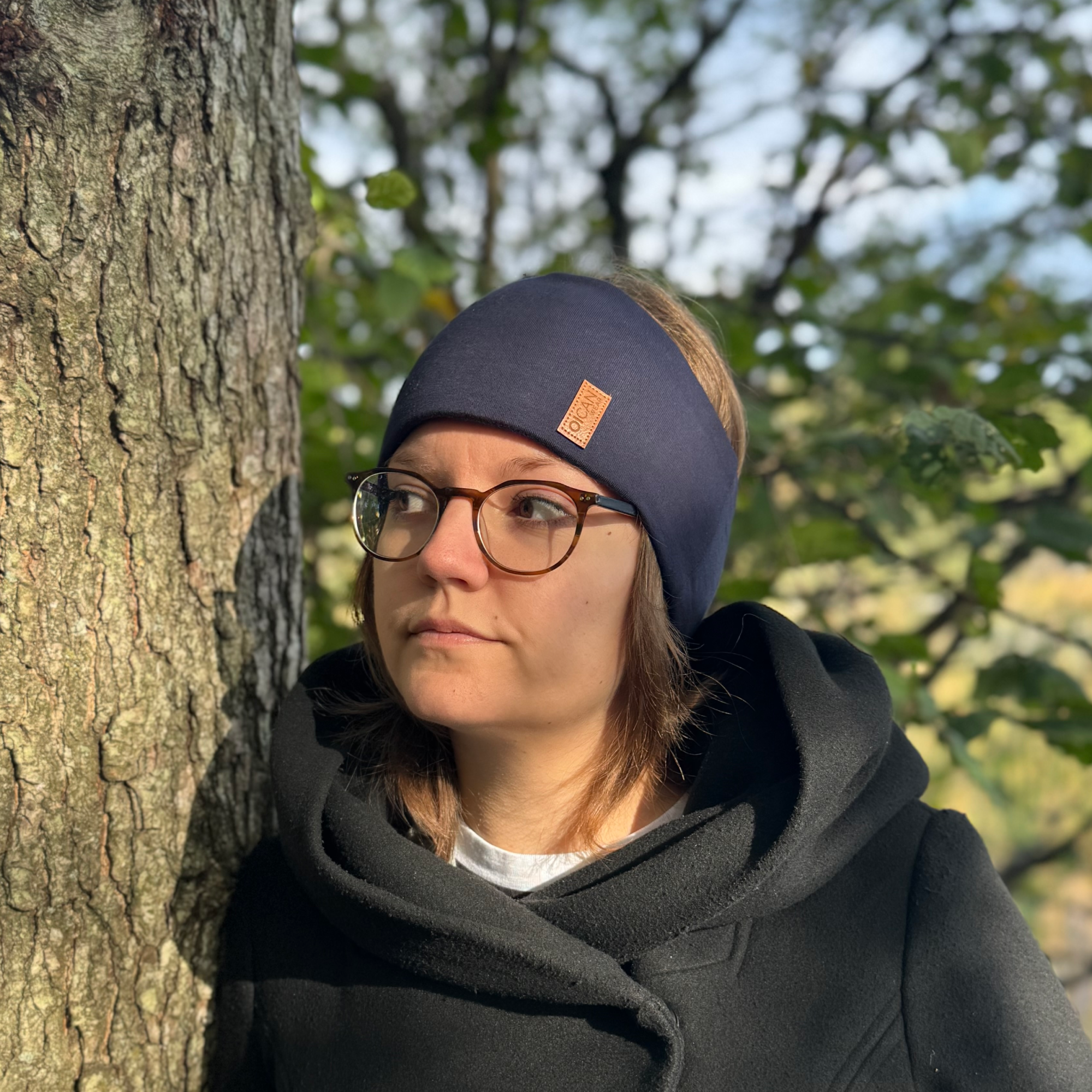 En tjej bär Navy Pannband från OICAN i skogen