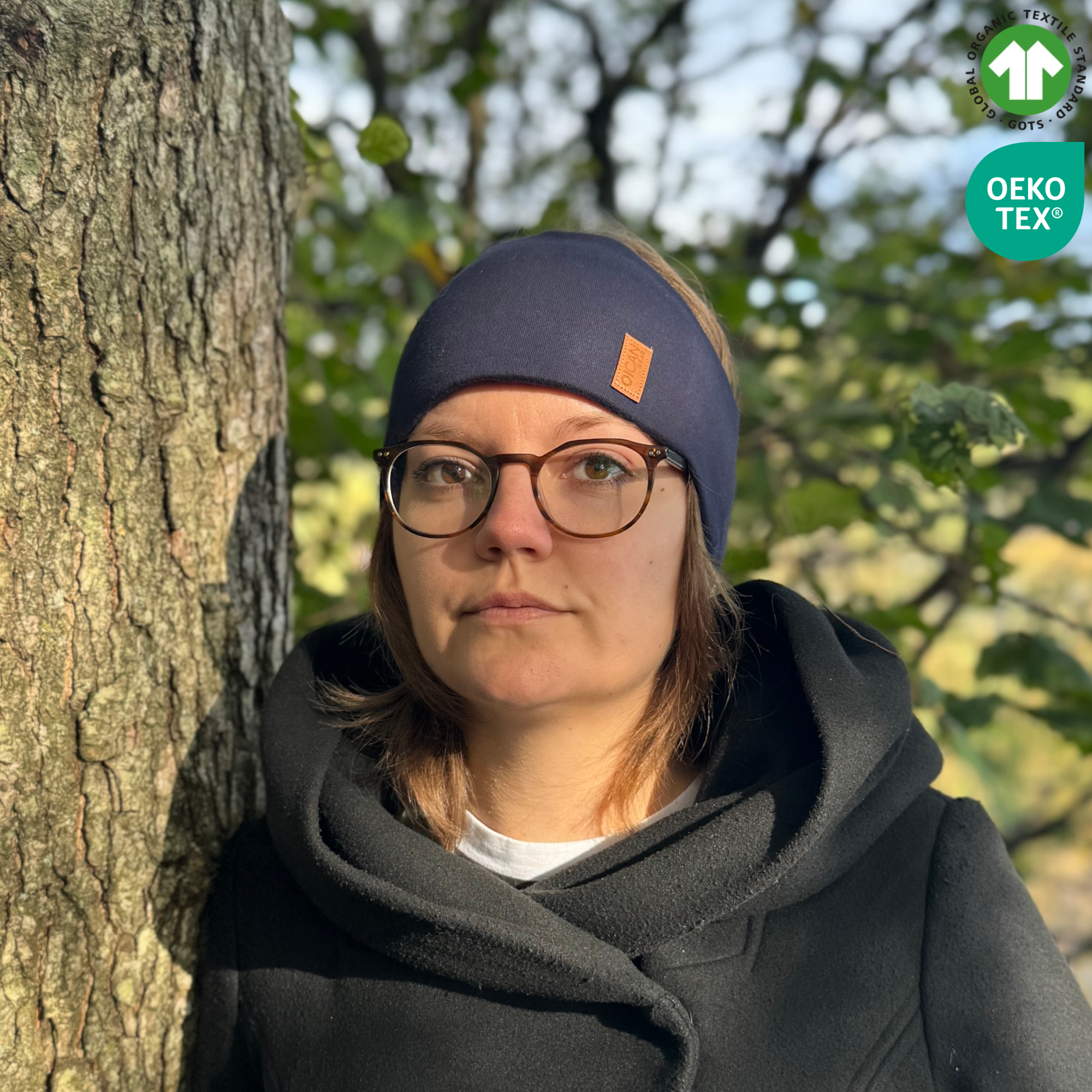 Tjej med blått pannband från OICAN vid ett träd. Ikoner höger hörn