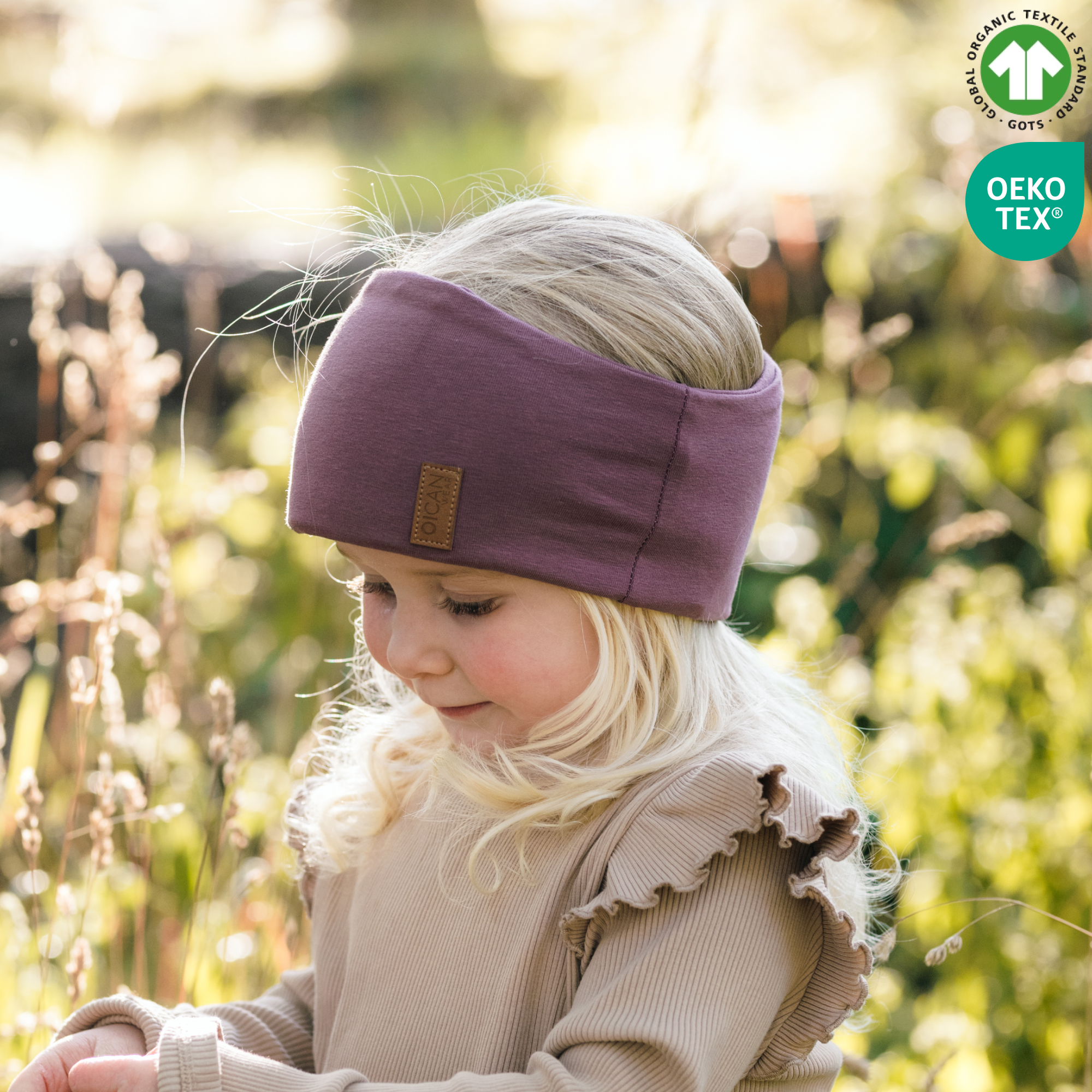 Flicka med lila pannband i naturen