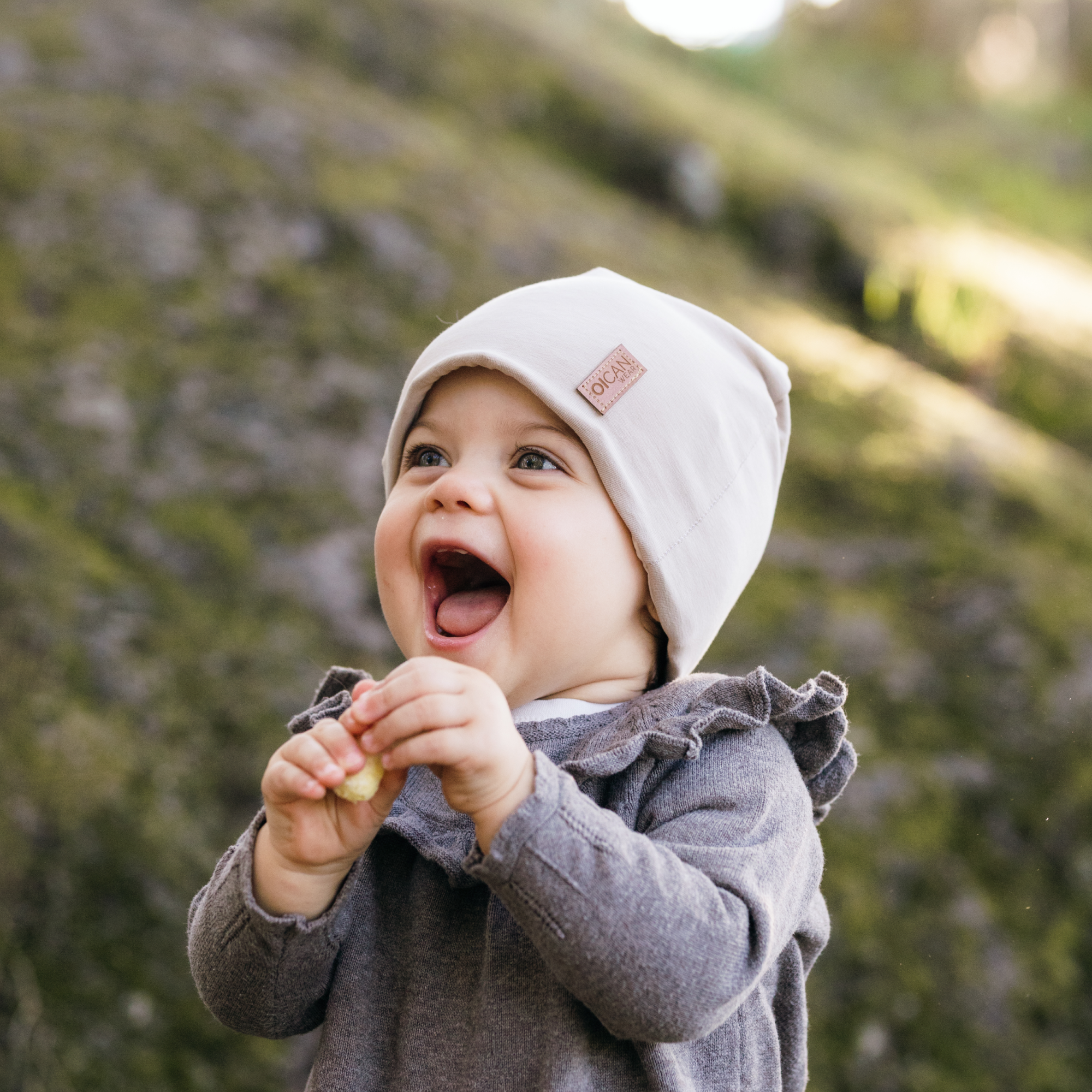 Flicka med beige Safehat i naturen, jätteglad