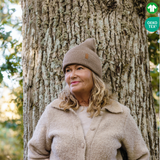 Dam bär brun stickad mössa i skogen