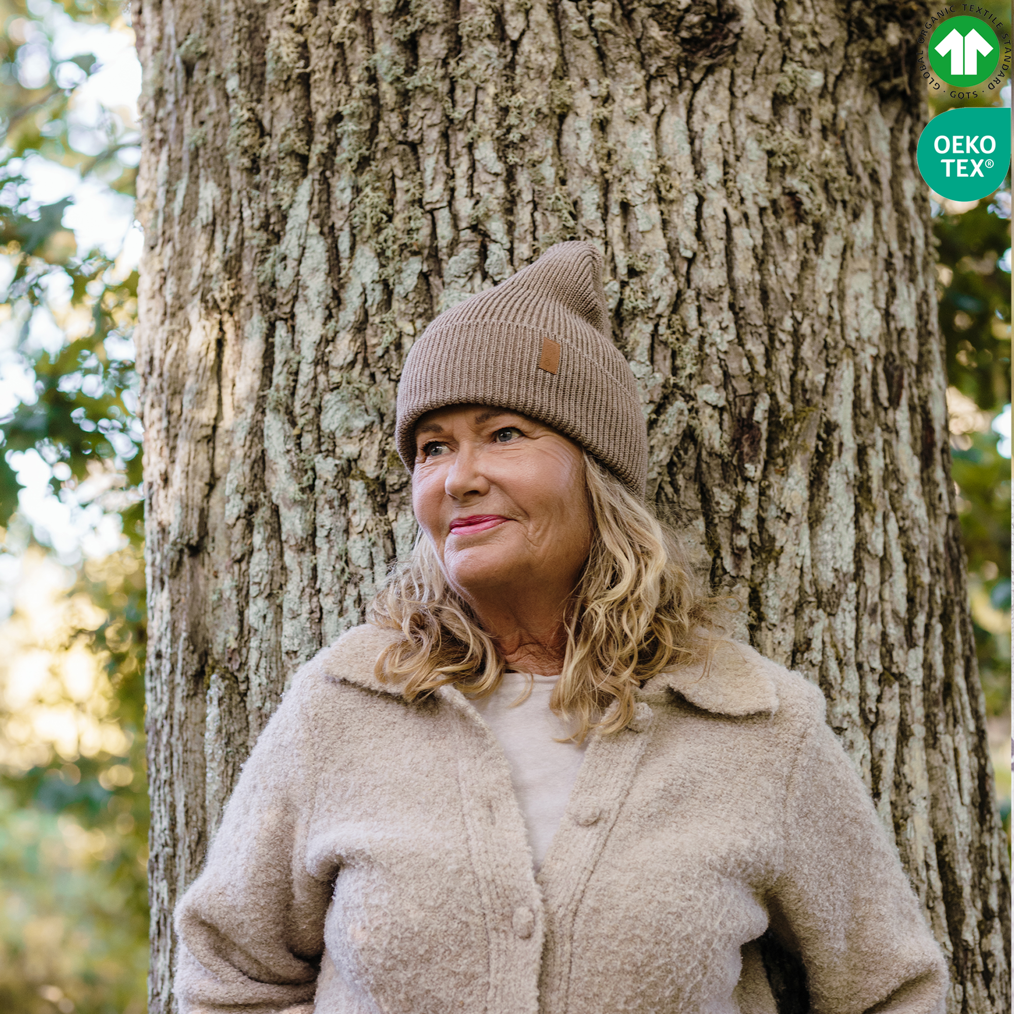 Dam bär brun stickad mössa i skogen