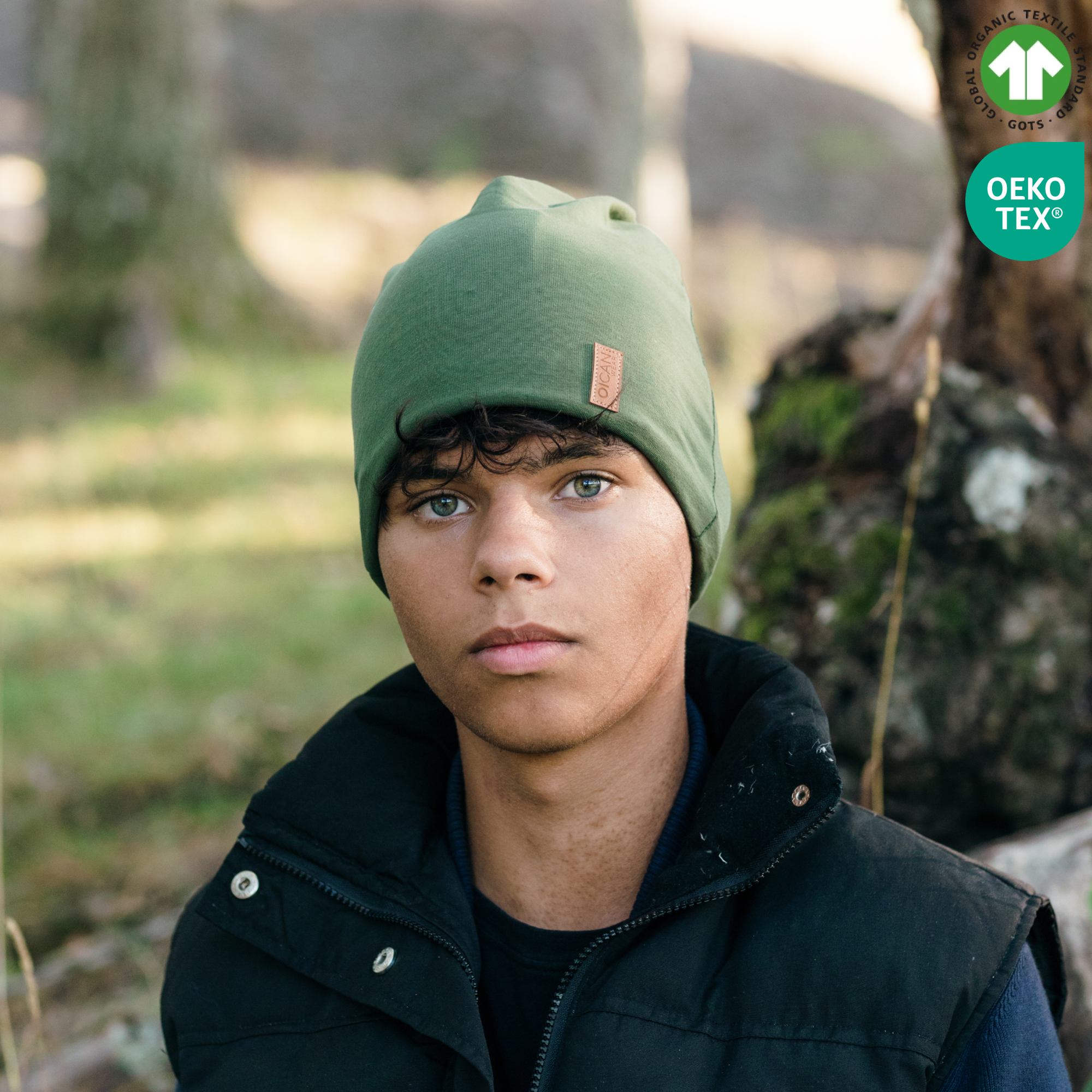 Kille bär safehat i färgen grön i naturen