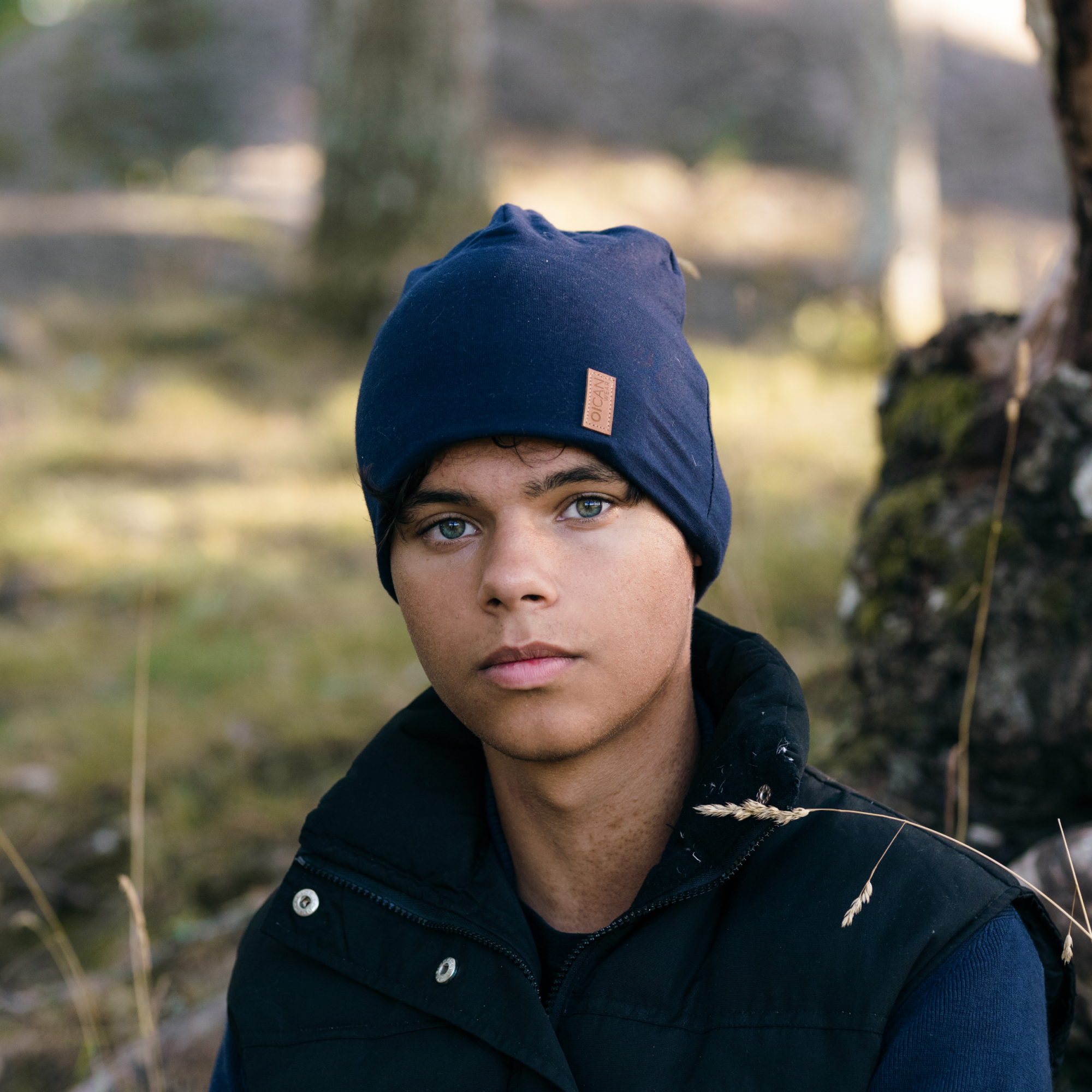 Kille i naturen bär SafeHat Navy och kollar in i kameran