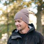 Man bär taupe SafeHat med utomhuskläder