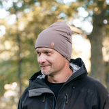 Man bär taupe SafeHat med utomhuskläder