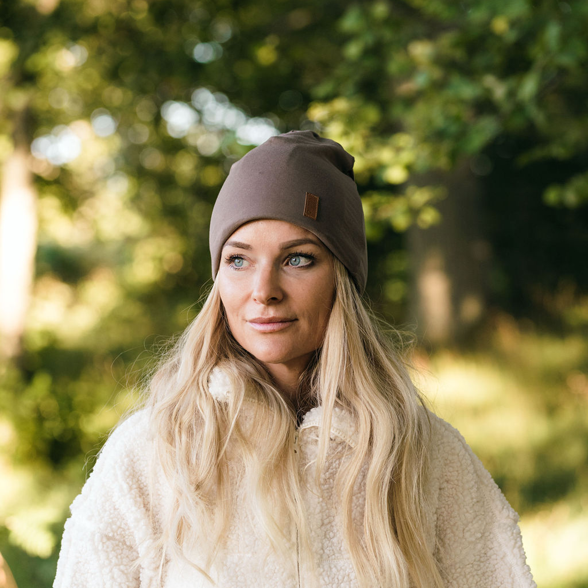 Tjej i skogen bär SafeHat Taupe